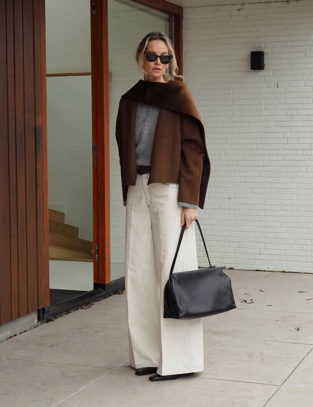 Baggy white jeans with a brown scarf ciar and grey sweater.