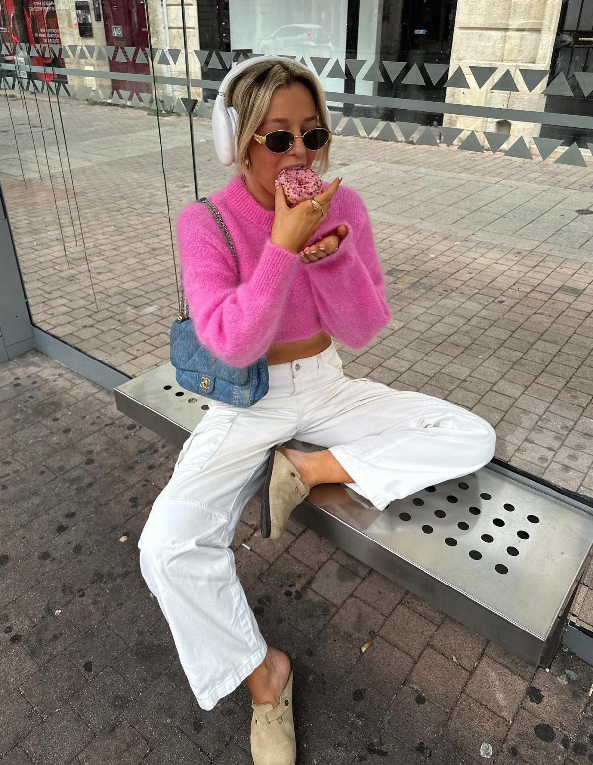 White jeans outfit with a hot pink sweater and Birkenstock clogs.