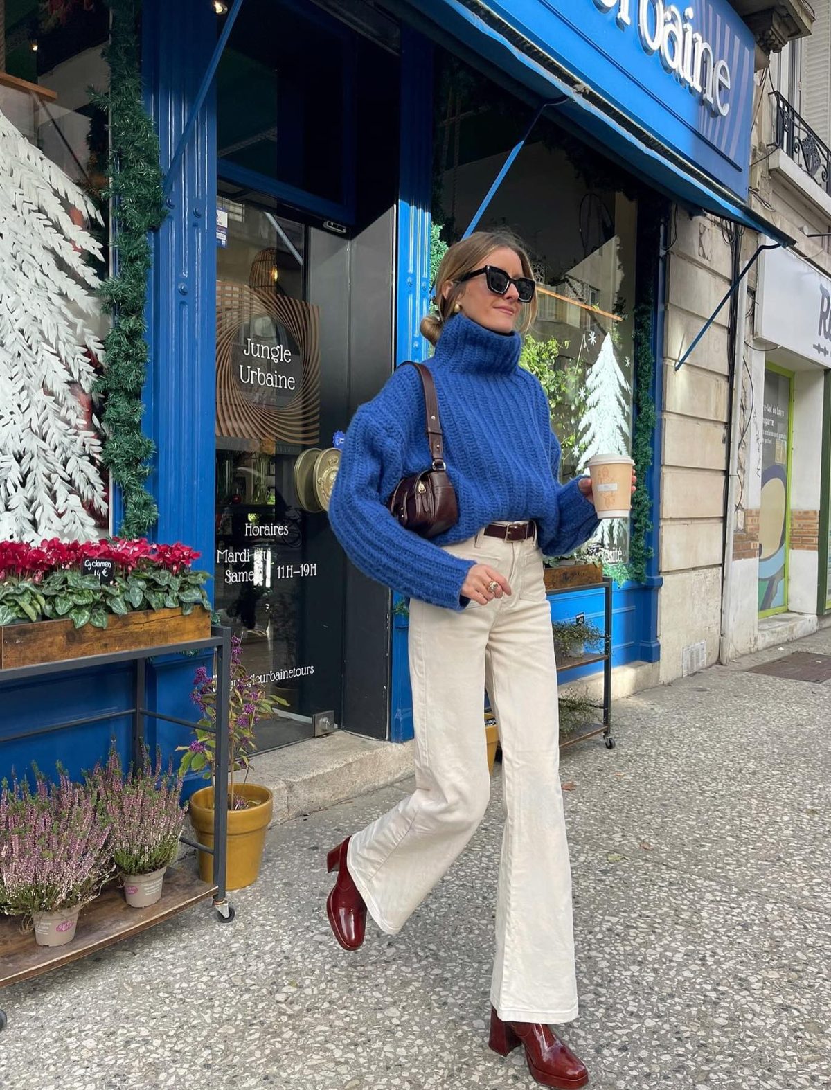 Cream-colored flare jeans witha blue sweater and brown boots.